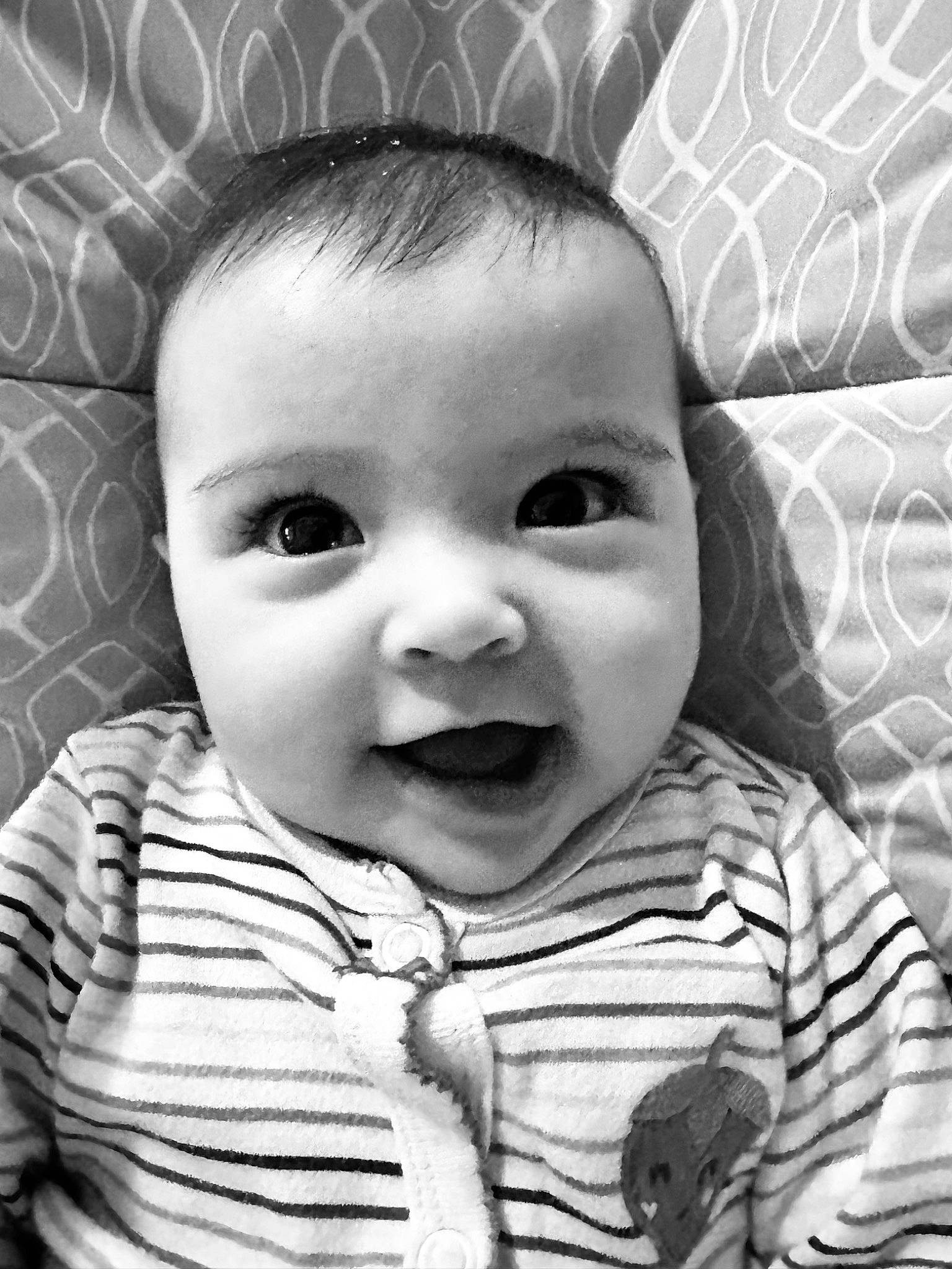 Marabella is registered to the contest to win money with this photo: baby, baby_toddler_clothing, black, cheek, chin, eye, eyebrow, eyelash, face, head, iris, lip, mouth, nose, organ, person, photograph, skin, sleeve, smile