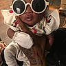 baby, child, sunglasses, white_sunglasses, tattooed_hand, cute_outfit, minnie_mouse, strawberry_print, infant, hand, person, indoor, fashion, glasses, portrait, cozy, cute, young_child, holding, funny