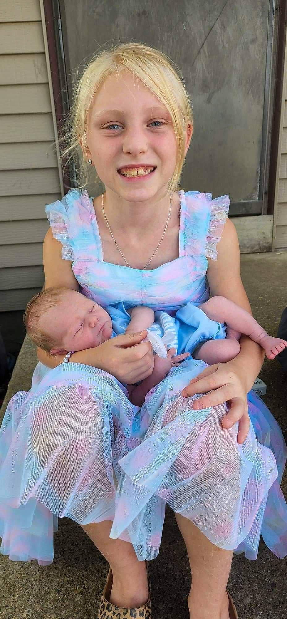 Claire is registered to the contest to win money with this photo: baby_toddler_clothing, blond, child, dress, electric_blue, event, face, fun, hair, hand, happy, iris, jewellery, joy, lap, necklace, person, pink, sitting, skin