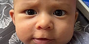 Alexander is registered to the contest to win money with this photo: baby, infant, face, eyes, expression, clothing, space_theme, onesie, hand, indoor, closeup, cute, child, portrait, curious, cartoon_background, soft_lighting, baby_gesture, human, young