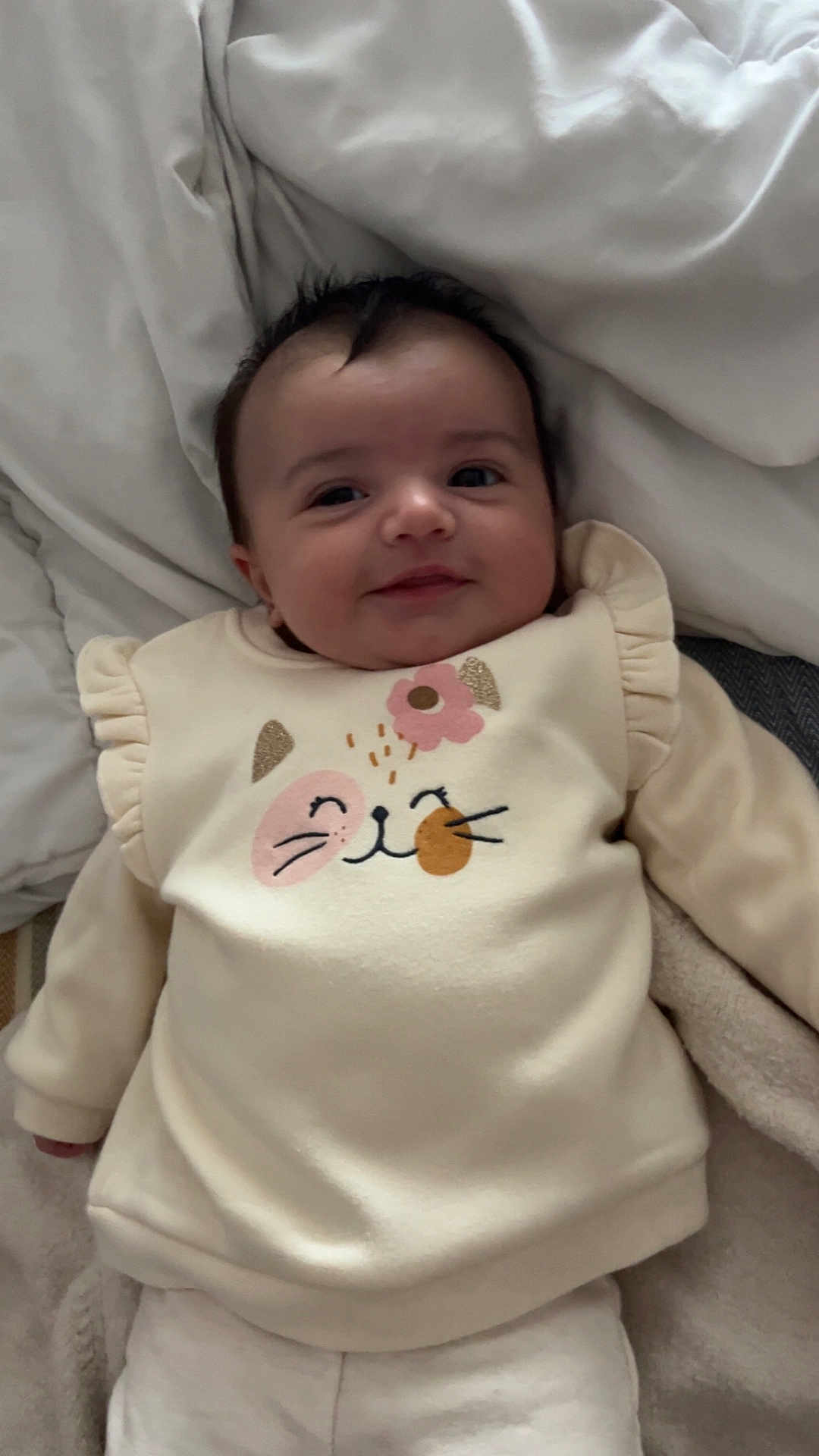 Violette participe au concours pour gagner de l'argent avec cette photo : baby, infant, smile, face, cute, clothing, sleeves, blanket, soft, lying_down, child, young, indoors, cozy, warm, comfort, portrait, expression, happy, apparel