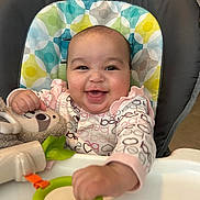 Alanna joined the competition — help win amazing prizes! baby, child, infant, smiling, happy, portrait, high_chair, indoor, toy, plush_toy, stuffed_animal, baby_clothing, long_sleeves, patterned_clothing, playful, seated, reaching, colorful, nursery, close_up