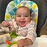 baby, child, infant, smiling, happy, portrait, high_chair, indoor, toy, plush_toy, stuffed_animal, baby_clothing, long_sleeves, patterned_clothing, playful, seated, reaching, colorful, nursery, close_up