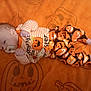 baby, infant, pacifier, orange_blanket, pumpkin_pattern, halloween_theme, clothing, sleepwear, face, head, hands, feet, lying_down, cute, child, young, indoor, blanket, pattern, festive
