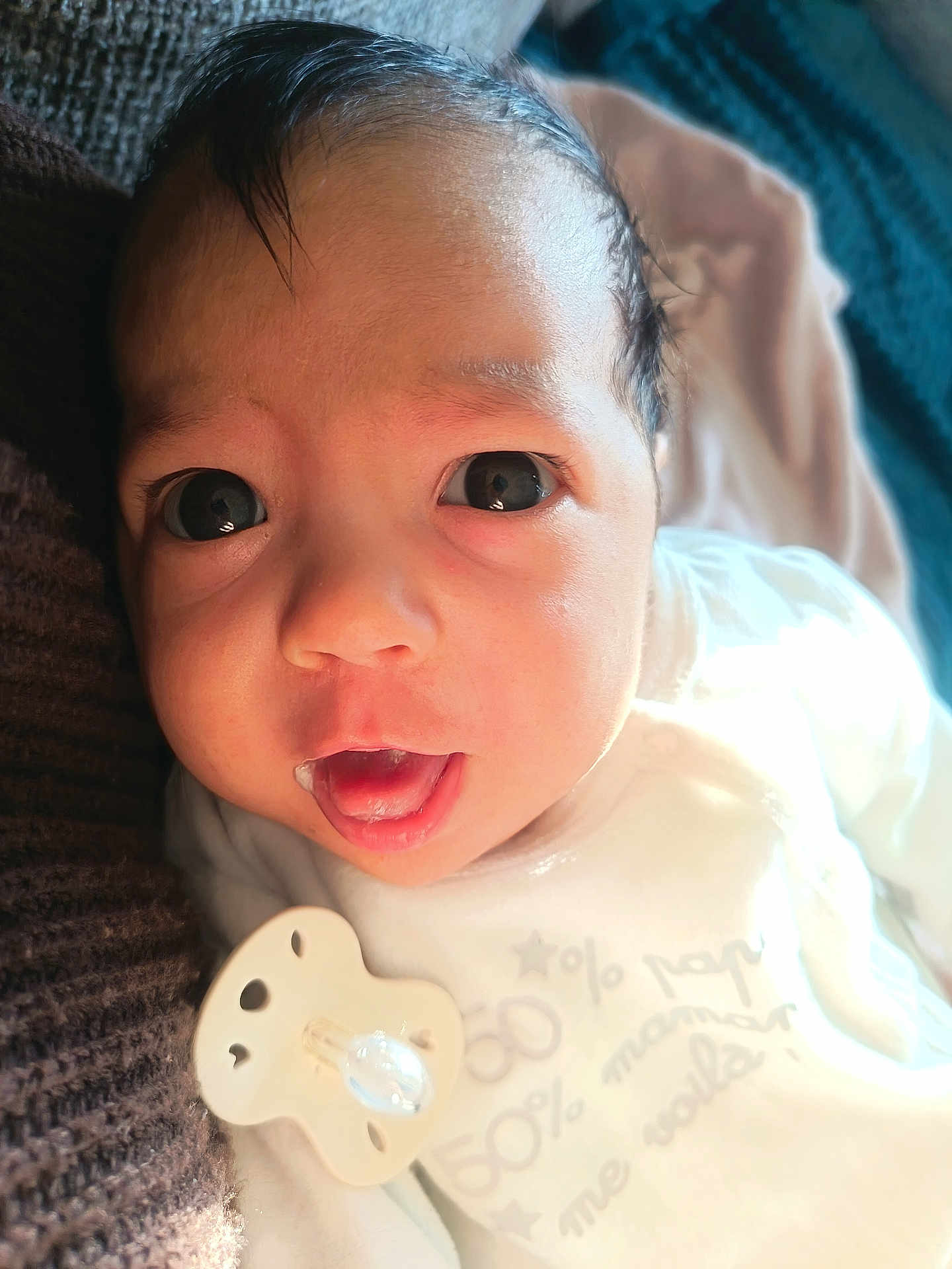 Bayan participe au concours pour gagner de l'argent avec cette photo : baby, infant, close_up, face, eyes, pacifier, blanket, sleepwear, mouth_open, skin, hair, cute, newborn, lying_down, soft_light, indoors, comfort, expression, person, portrait