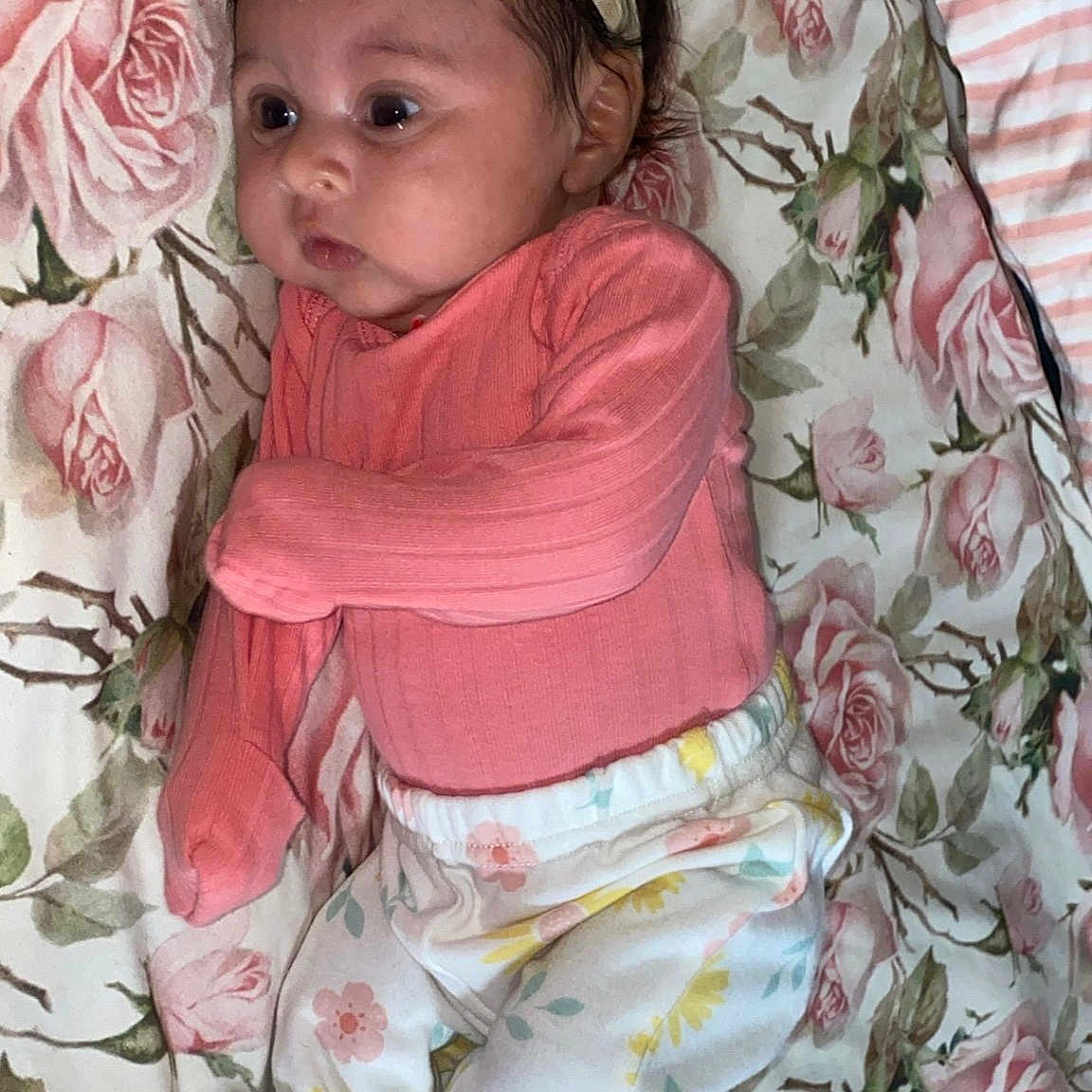 Luzleiny is registered to the contest to win money with this photo: baby, baby_girl, blanket, bow, child, chubby_cheeks, curious, cute, floral_pants, headband, indoors, infant, lying_down, person, pink_clothing, portrait, rose_pattern, sleepwear, socks, soft_lighting