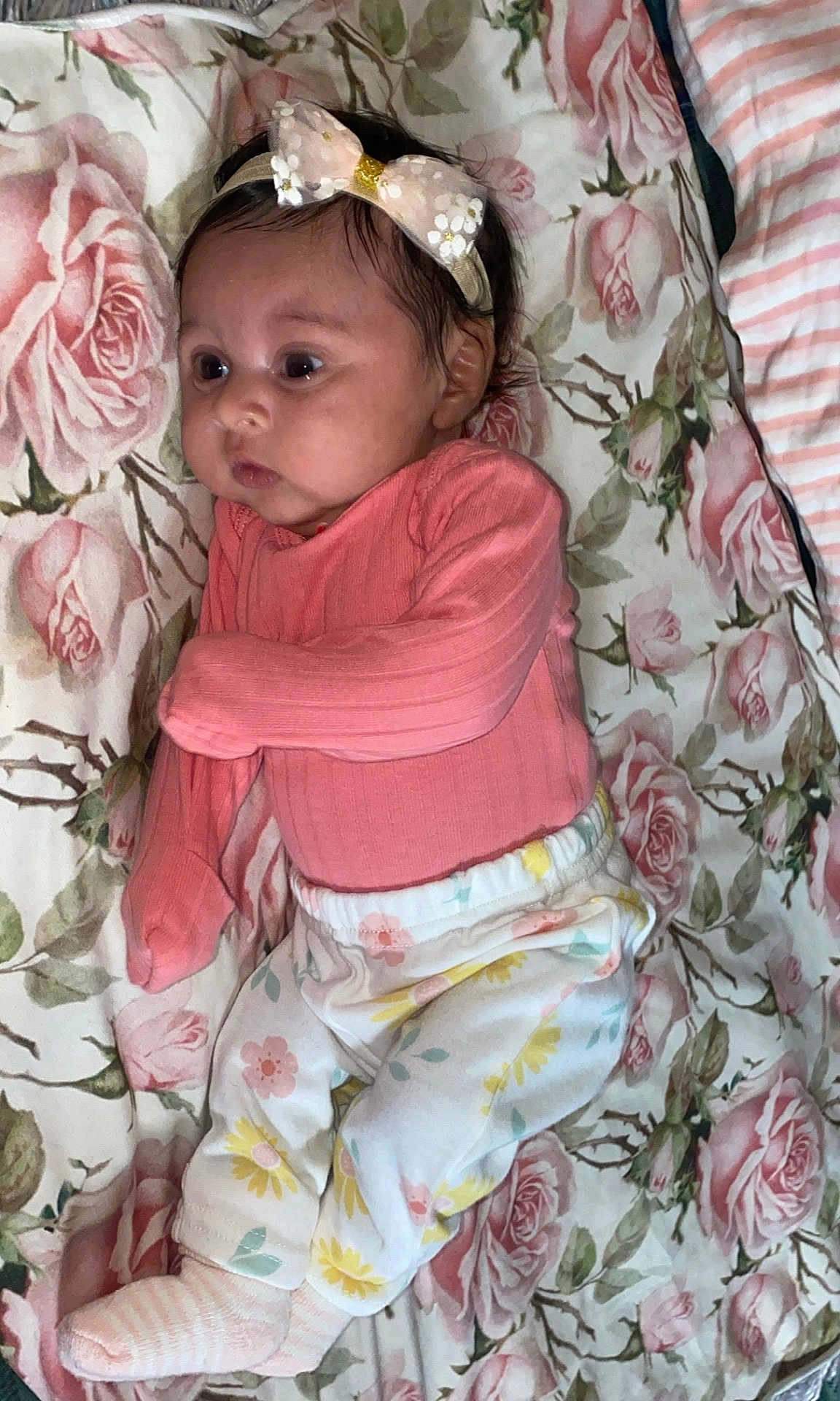 Luzleiny is registered to the contest to win money with this photo: baby, infant, child, headband, bow, pink_clothing, floral_pants, socks, blanket, rose_pattern, lying_down, cute, chubby_cheeks, curious, indoors, soft_lighting, portrait, person, baby_girl, sleepwear