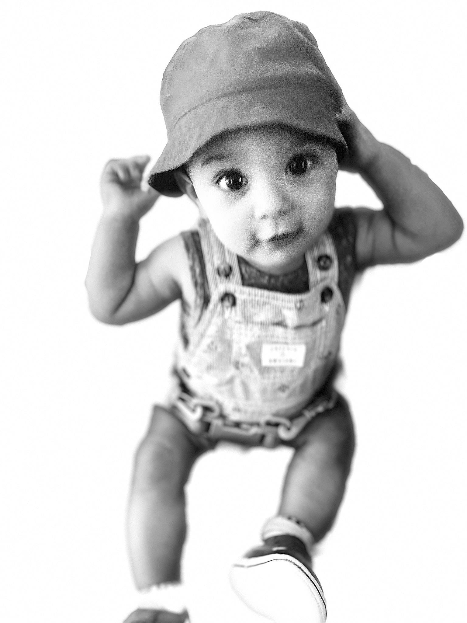 Fabian is registered to the contest to win money with this photo: baby, baby_toddler_clothing, black_and_white, cap, child, elbow, eye, fashion_accessory, finger, flash_photography, fun, gesture, happy, headwear, monochrome, monochrome_photography, person, play, sleeve, style