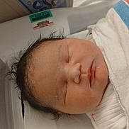 Journie is registered to the contest to win money with this photo: newborn, baby, sleeping, hospital, blanket, swaddle, infant, portrait, cute, face, head, hair, peaceful, child, person, indoors, closeup, resting, healthcare, newborn_bassinet