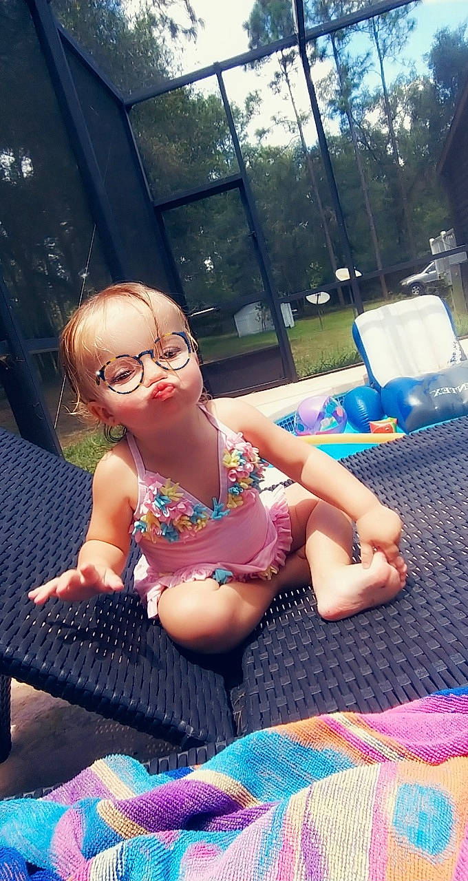 Riverlyn is registered to the contest to win money with this photo: beauty, black_hair, chest, child, cool, eyewear, fun, glasses, grass, happy, leg, leisure, person, summer, sunglasses, sunlight, swimwear, thigh, toddler, tree