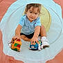 Andre is registered to the contest to win money with this photo: toddler, child, toy_cars, play_tunnel, blue_shirt, white_shoes, curly_hair, indoor_play, cute, smiling, sitting, playtime, colorful, soft_toys, happy, young_child, portrait, casual_clothing, fun, exploring
