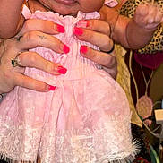 Mckenna joined the competition — help win amazing prizes! baby, child, pink_dress, socks, hands, adult, nail_polish, face, fingers, couch, leopard_print, home_interior, curious_expression, skin, person, furniture, portrait, indoor, holding, cute