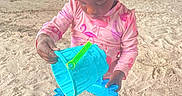 Marsai joined the competition — help win amazing prizes! barefoot, beach, beads, blue_bucket, bucket, child, daytime, fun, hair, outdoor, person, pink_clothing, play, sand, sand_mold, sand_toys, summer, toy, under_bridge, young_child