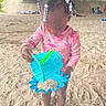 Marsai joined the competition — help win amazing prizes! child, beads, hair, sand, bucket, blue_bucket, sand_mold, beach, play, toy, barefoot, pink_clothing, outdoor, under_bridge, sand_toys, person, young_child, summer, daytime, fun