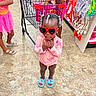Marsai is registered to the contest to win money with this photo: aisle, blue, child, clothing, cute, floor, hair_beads, indoor, person, pink, red, retail, sandals, shopping, shopping_cart, snacks, standing, store, sunglasses, young_child
