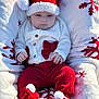 baby, infant, christmas_hat, knitwear, red_pants, white_sweater, pom_pom, blanket, snowflake_pattern, holiday, cute, child, outdoor, seasonal, festive, cozy, warm_clothing, portrait, sitting, soft_light