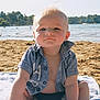 baby, child, beach, sand, water, towel, shirt, sunlight, outdoor, summer, portrait, blue_shirt, swimwear, sitting, face, cute, young_child, nature, daytime, vacation