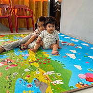 Dariel Kaled is registered to the contest to win money with this photo: child, children, baby, toddler, play_mat, colorful, indoor, curly_hair, sitting, floor, toy, plastic_chair, curtains, window, door, person, cute, smile, home, family