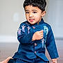 toddler, child, boy, blue_outfit, indoor, floor, kneeling, cute, portrait, face, hair, playful, expression, buttoned_jacket, embroidery, barefoot, young, person, smiling, skin