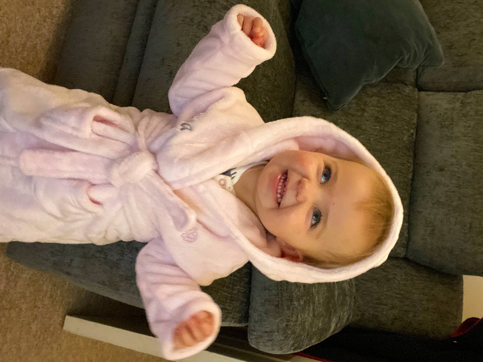 Ariya is registered to the contest to win money with this photo: baby_products, baby_toddler_clothing, cheek, child, comfort, flooring, fur, gesture, happy, head, human_body, joy, person, product, sitting, skin, sleeve, smile, thumb, toddler