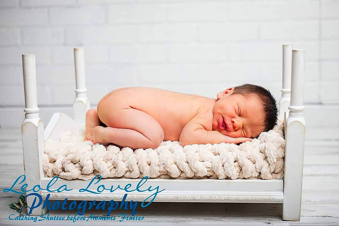 Bodhi is registered to the contest to win money with this photo: baby, baby_products, barefoot, bedding, bedtime, child, comfort, fashion_accessory, flooring, foot, human_leg, leisure, linens, pattern, person, portrait_photography, rectangle, room, sitting, toddler