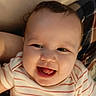 Baruk is registered to the contest to win money with this photo: baby, blanket, child, close_up, cozy, eyes, face, hair, happy, indoor, infant, laughing, mouth, person, portrait, shirt, sitting, smiling, striped_clothing, warm_lighting