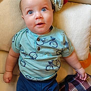 Baruk joined the competition — help win amazing prizes! baby, child, infant, portrait, face, blue_eyes, wide_eyed, sitting, couch, cushion, blanket, clothing, shirt, pants, indoors, home, cozy, smiling, photography, close_up