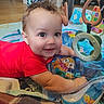 Baruk joined the competition — help win amazing prizes! baby, child, infant, smiling, happy, portrait, red_shirt, brown_hair, blue_eyes, activity_center, baby_toys, alphabet_blocks, play_mat, indoor, home, sitting, playtime, colorful, toy_ring, closeup