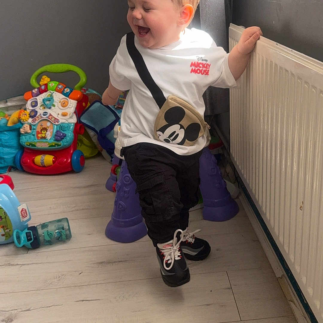 Rueben-James is registered to the contest to win money with this photo: adult, bathroom, boy, child, clothing, face, footwear, hardwood, head, indoors, male, man, pants, person, room, shoe, sitting, sneaker, toy, wood