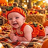 Anthony joined the competition — help win amazing prizes! autumn, autumn_leaves, baby, blanket, child, costume, cozy, festive, halloween, happy, harvest, infant, knitted_clothing, orange, outdoor, portrait, pumpkin_costume, pumpkins, smiling, warm_lighting