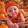 autumn, autumn_leaves, baby, blanket, child, costume, crocheted_hat, fall, farm, halloween, infant, orange_clothing, outdoor, portrait, pumpkin, pumpkin_patch, seasonal, sitting, smiling, warm_lighting