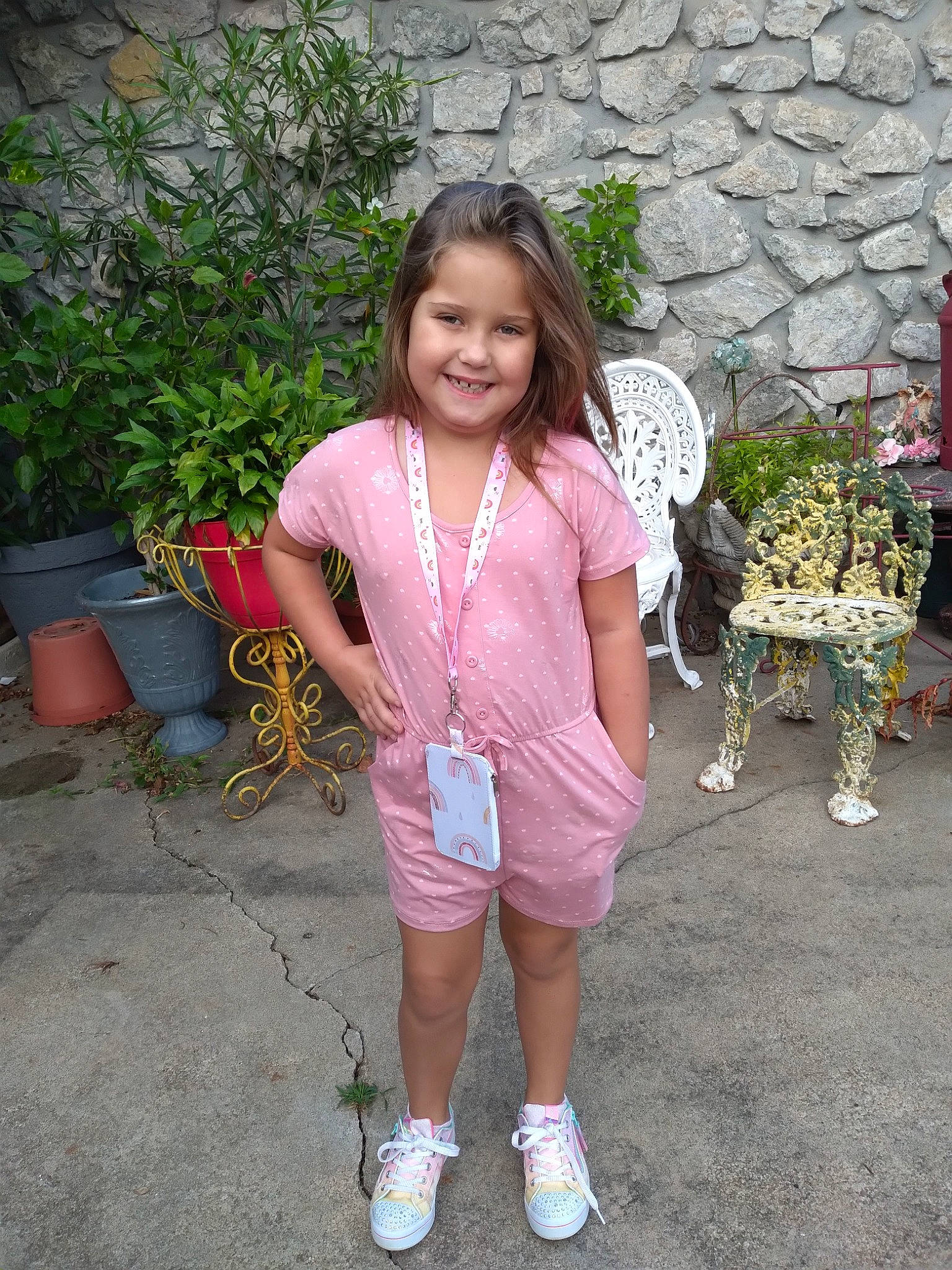 Lilly is registered to the contest to win money with this photo: baby_toddler_clothing, botany, child, eye, face, flowerpot, grass, hair, happy, head, joy, leg, leisure, mammal, person, pink, plant, sitting, smile, summer