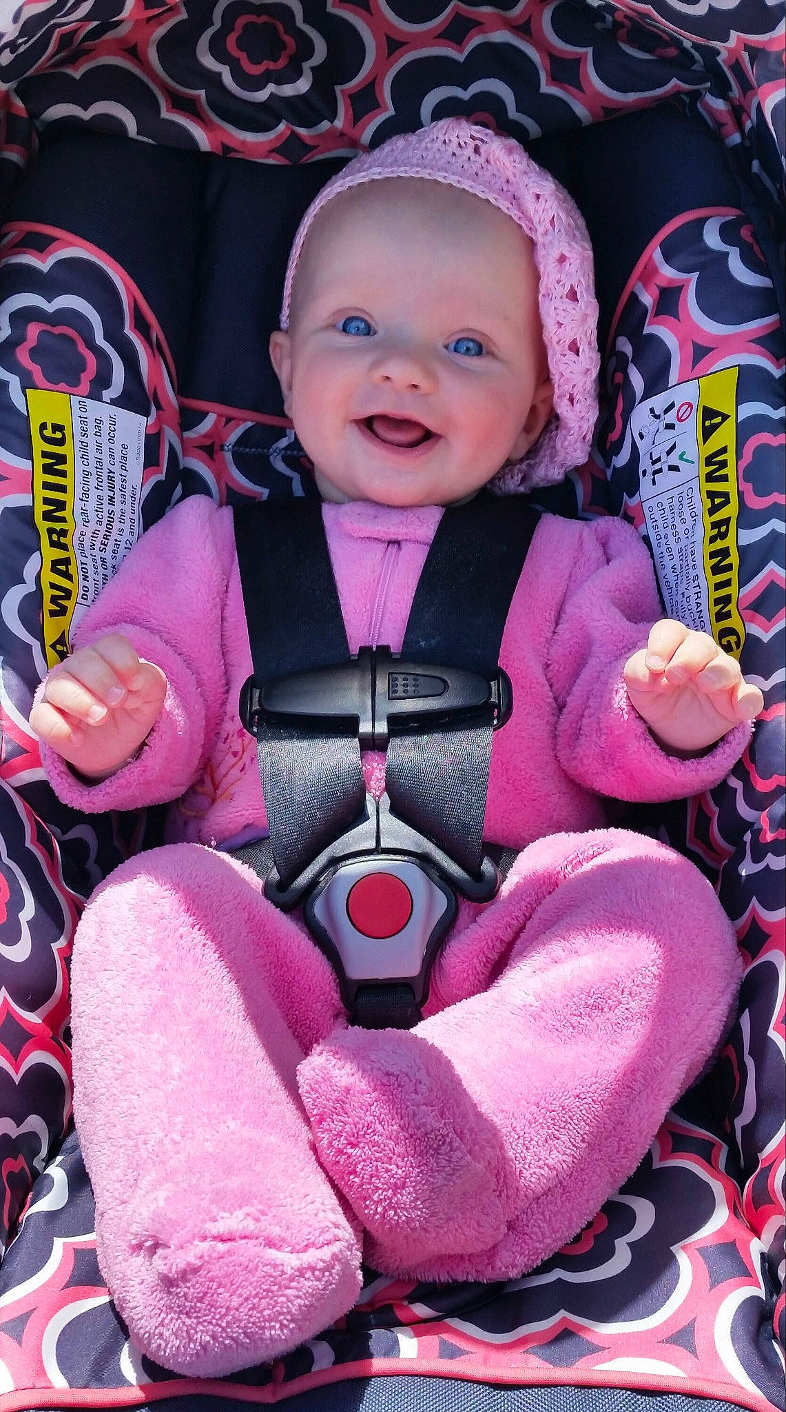 Charlee is registered to the contest to win money with this photo: baby, baby_carriage, baby_products, baby_toddler_clothing, car_seat, carmine, child, face, fun, happy, leisure, magenta, person, personal_protective_equipment, pink, purple, sitting, smile, steering_wheel, toddler
