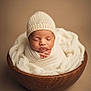 newborn, baby, infant, sleeping, knitted_hat, wrapped, wooden_bowl, blanket, soft_texture, cute, portrait, studio, warm_colors, cozy, child, peaceful, resting, small_hands, headwear, baby_photography