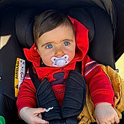 Esmée participe au concours pour gagner de l'argent avec cette photo : baby, car_seat, pacifier, red_hoodie, blue_eyes, child, blanket, straps, safety_belt, infant, cute, portrait, young_child, indoors, clothing, hand, seat, child_safety, baby_fashion, casual