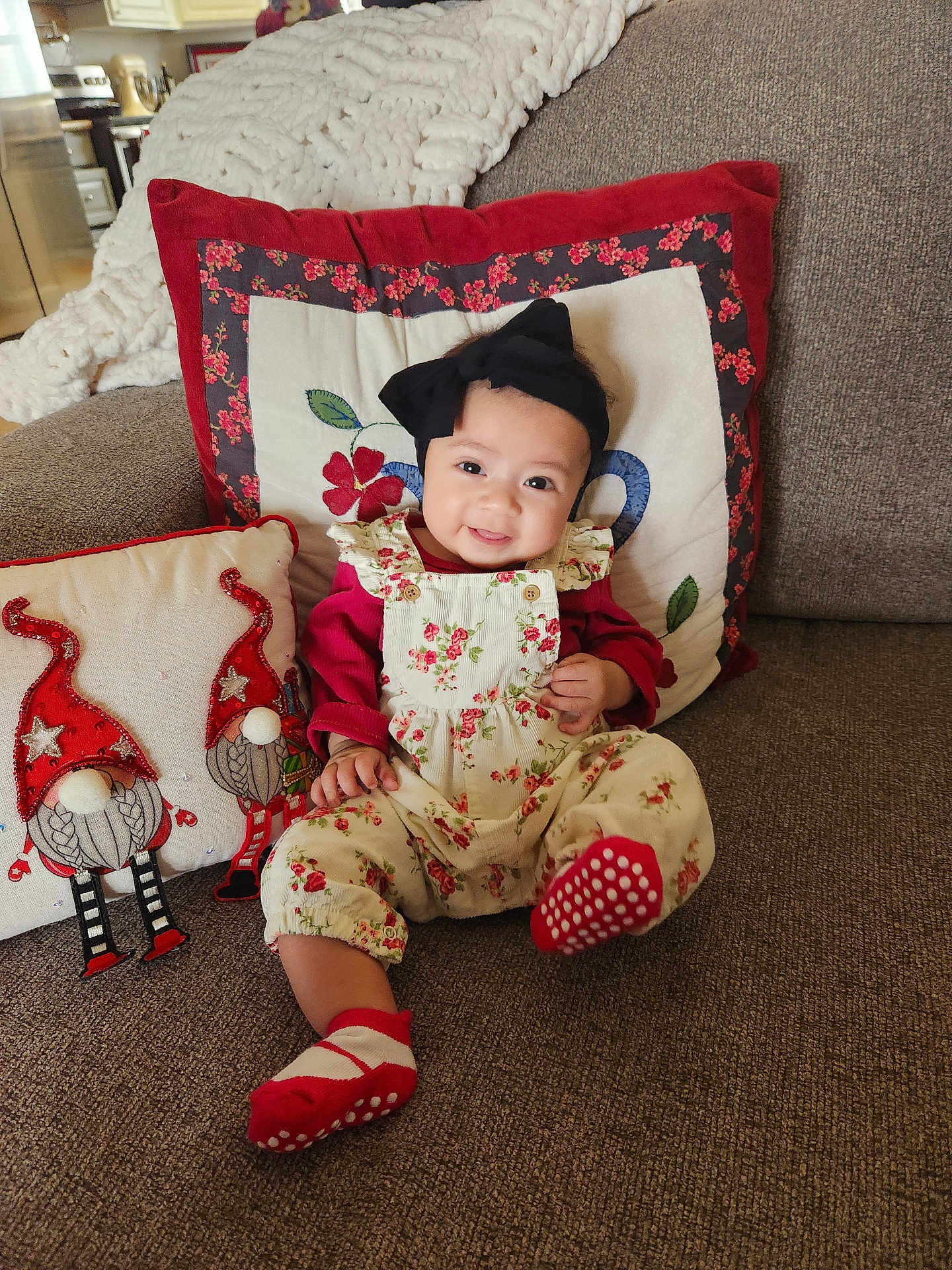 Cosette joined the competition — help win amazing prizes! baby, child, smiling, sitting, couch, pillow, headband, floral, clothing, indoors, home, cozy, cute, red, white, decor, happy, infant, portrait, comfortable