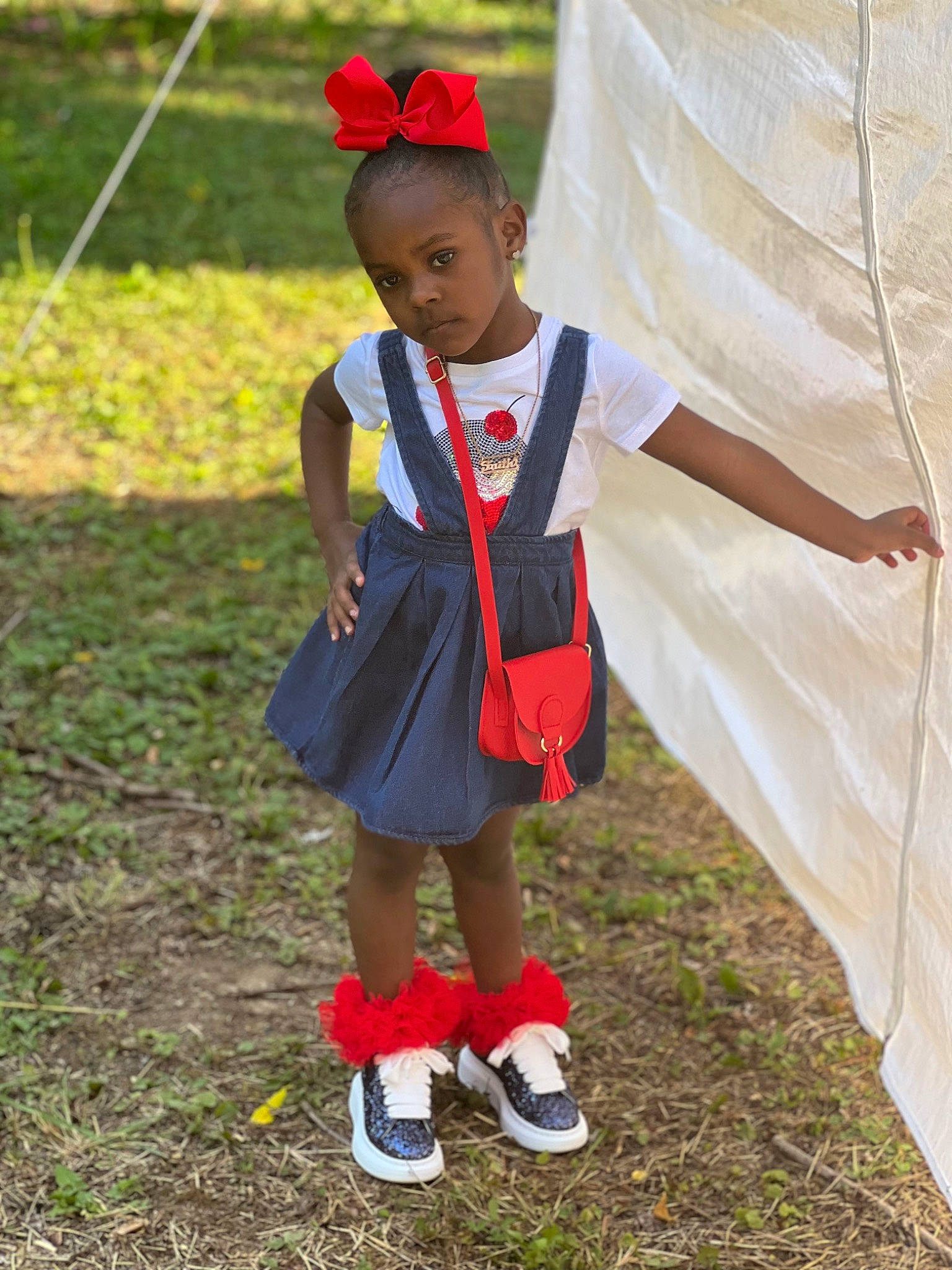 Faith is registered to the contest to win money with this photo: bag, baseball_cap, boot, cap, competition_event, event, footwear, fun, grass, hat, leisure, luggage_and_bags, person, player, recreation, school_uniform, shoe, sneakers, toddler, tradition