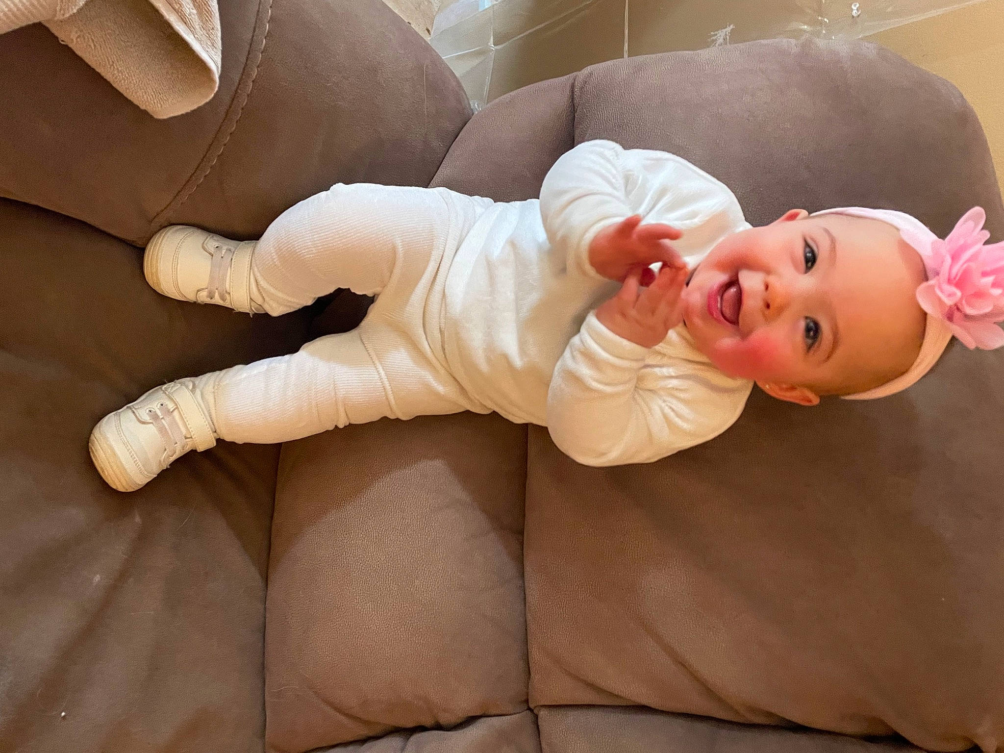 Mary is registered to the contest to win money with this photo: baby, baby_toddler_clothing, comfort, eye, finger, flooring, foot, gesture, hand, head, headgear, human_body, joy, knee, lip, person, skin, sleeve, smile, thigh