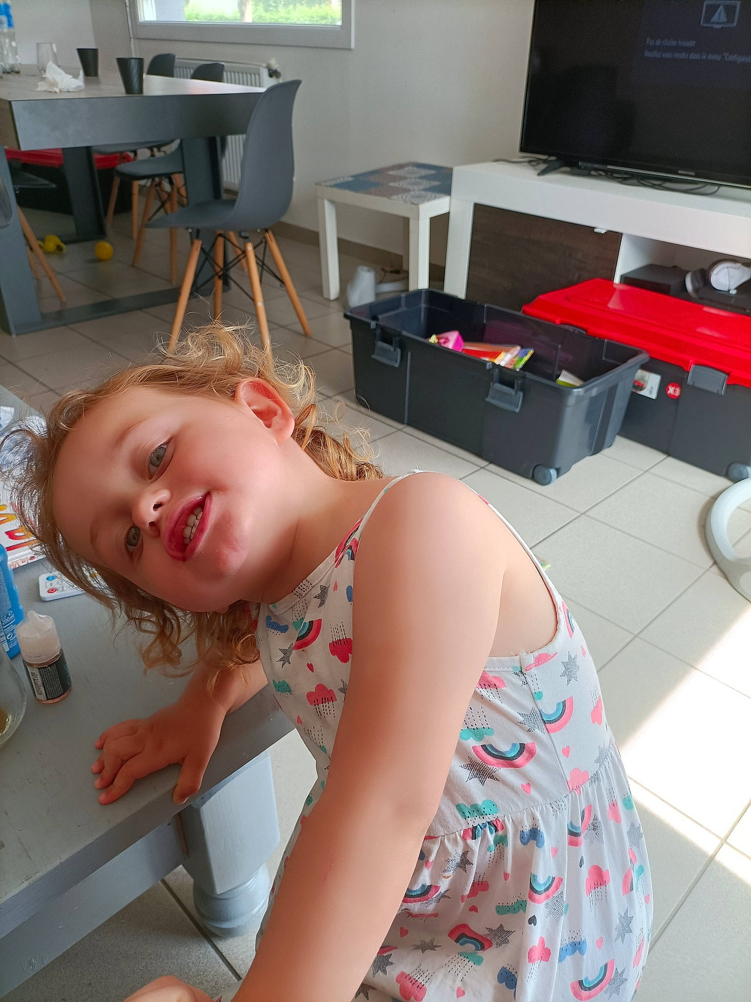 Alice participe au concours pour gagner de l'argent avec cette photo : arm, baby, baby_toddler_clothing, chair, child, comfort, floor, flooring, fun, human_leg, joint, joy, knee, leg, mouth, pattern, person, room, smile, television