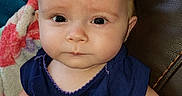 Cora is registered to the contest to win money with this photo: arm, baby, blanket, blue_shirt, child, clothing, couch, cute, expression, eyes, face, head, home, indoor, mohawk, person, portrait, sitting, skin, young