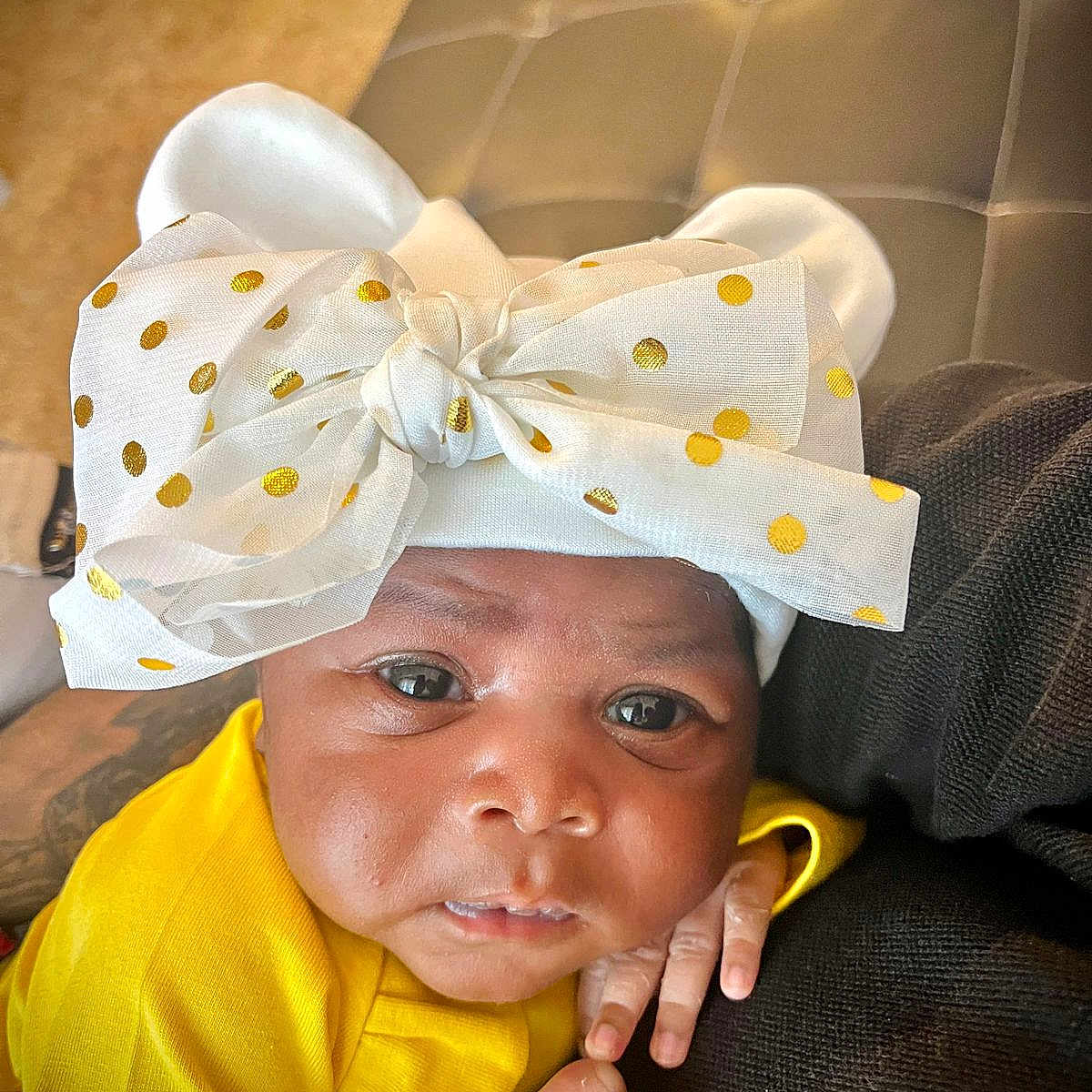 Yasmin a rejoint le concours — aidez-le/la à gagner de superbes lots ! baby, bow, child, closeup, cute, expression, face, fashion_accessory, hand, headwear, indoor, infant, newborn, person, polka_dot, portrait, resting, skin, soft_texture, yellow_clothing