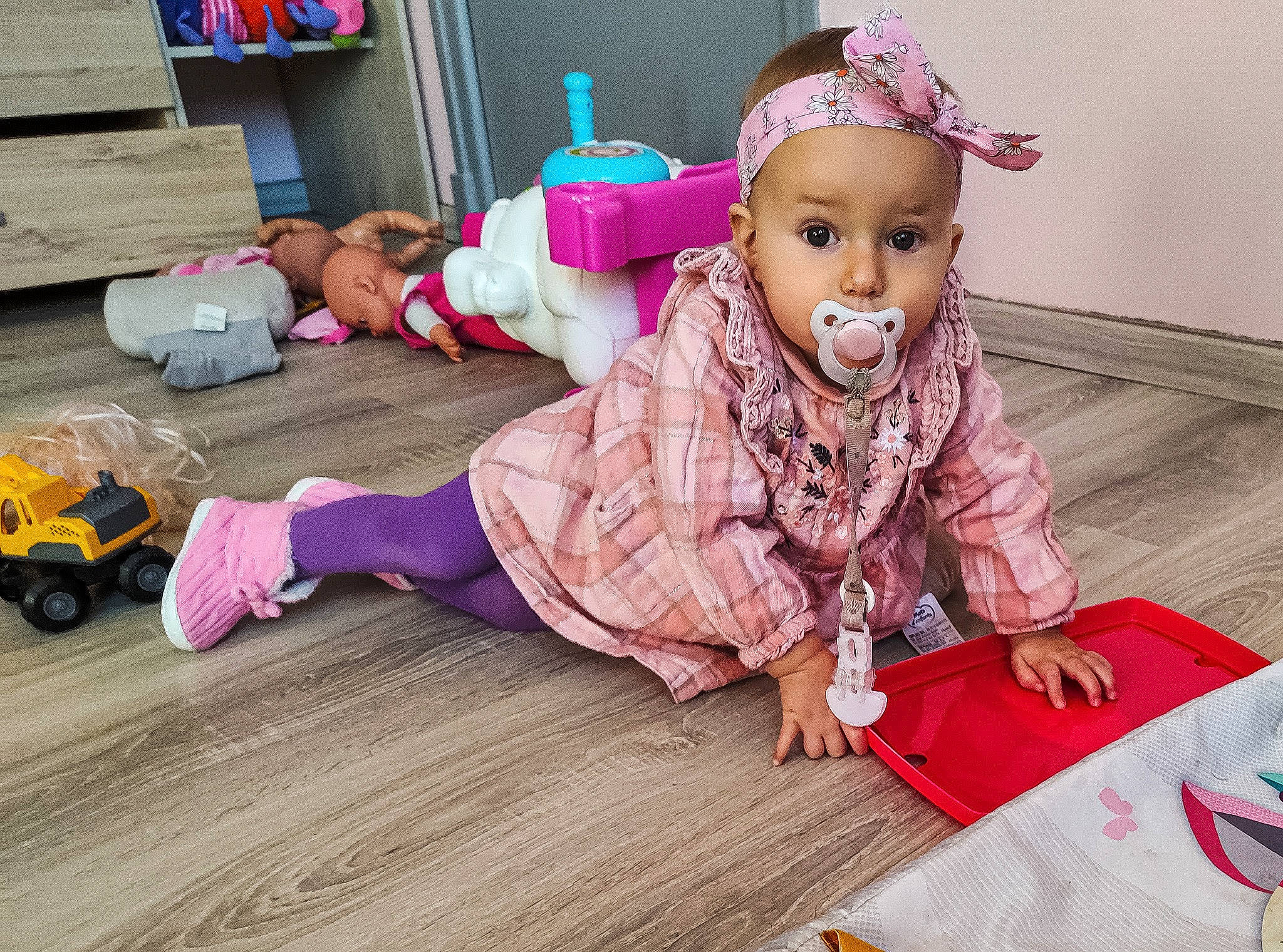 Alicia a rejoint le concours — aidez-le/la à gagner de superbes lots ! baby_toddler_clothing, child, floor, flooring, fun, happy, hardwood, leisure, magenta, person, pink, play, purple, room, sitting, smile, textile, toddler, toy, wheel