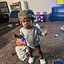 Rayven joined the competition — help win amazing prizes! toddler, child, indoor, carpet, hat, camouflage, clothing, white_crocs, toys, blanket, living_room, expression, standing, floor, furniture, television, earrings, playtime, person, cute