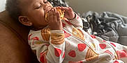 Rayven is registered to the contest to win money with this photo: toddler, child, eating, food, sandwich, onesie, pajamas, cute, couch, blanket, indoor, relaxed, cozy, happy, person, portrait, snack, cute_clothing, baby, leisure