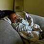 baby, sleeping, pacifier, blanket, striped_clothing, couch, indoor, soft_light, cozy, infant, resting, comfort, child, home, furniture, portrait, relaxation, peaceful, wrapped, young