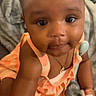 Capri joined the competition — help win amazing prizes! baby, blanket, bracelet, child, close_up, curious, cute, dress, face, girl, indoors, infant, necklace, orange_bows, peach_color, pigtails, portrait, skin, smiling, soft_toy