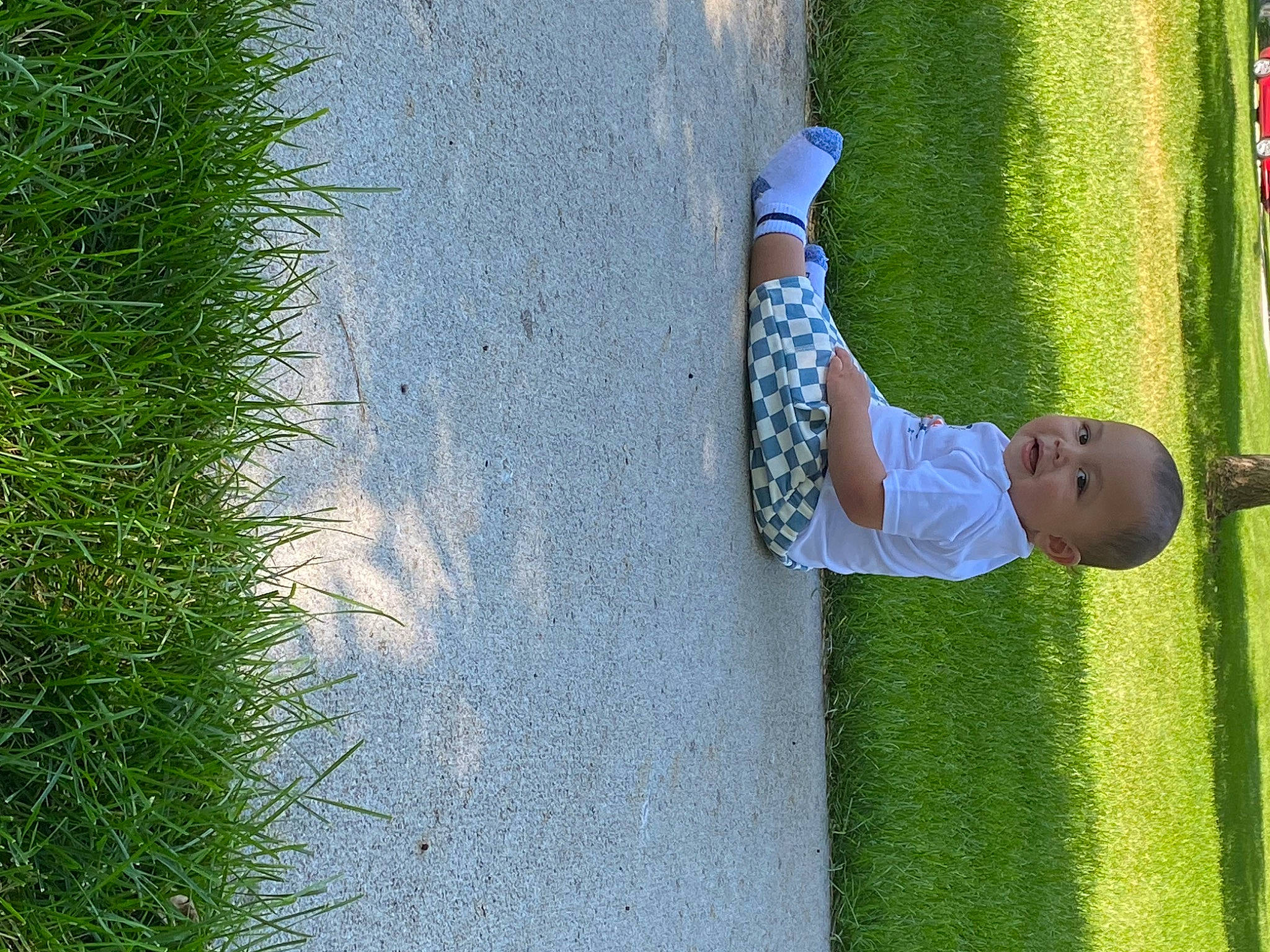 Spencer is registered to the contest to win money with this photo: asphalt, child, concrete, fun, grass, grass_family, lawn, leisure, people_in_nature, person, plant, recreation, road, road_surface, shadow, shrub, sidewalk, sunglasses, toddler, tree