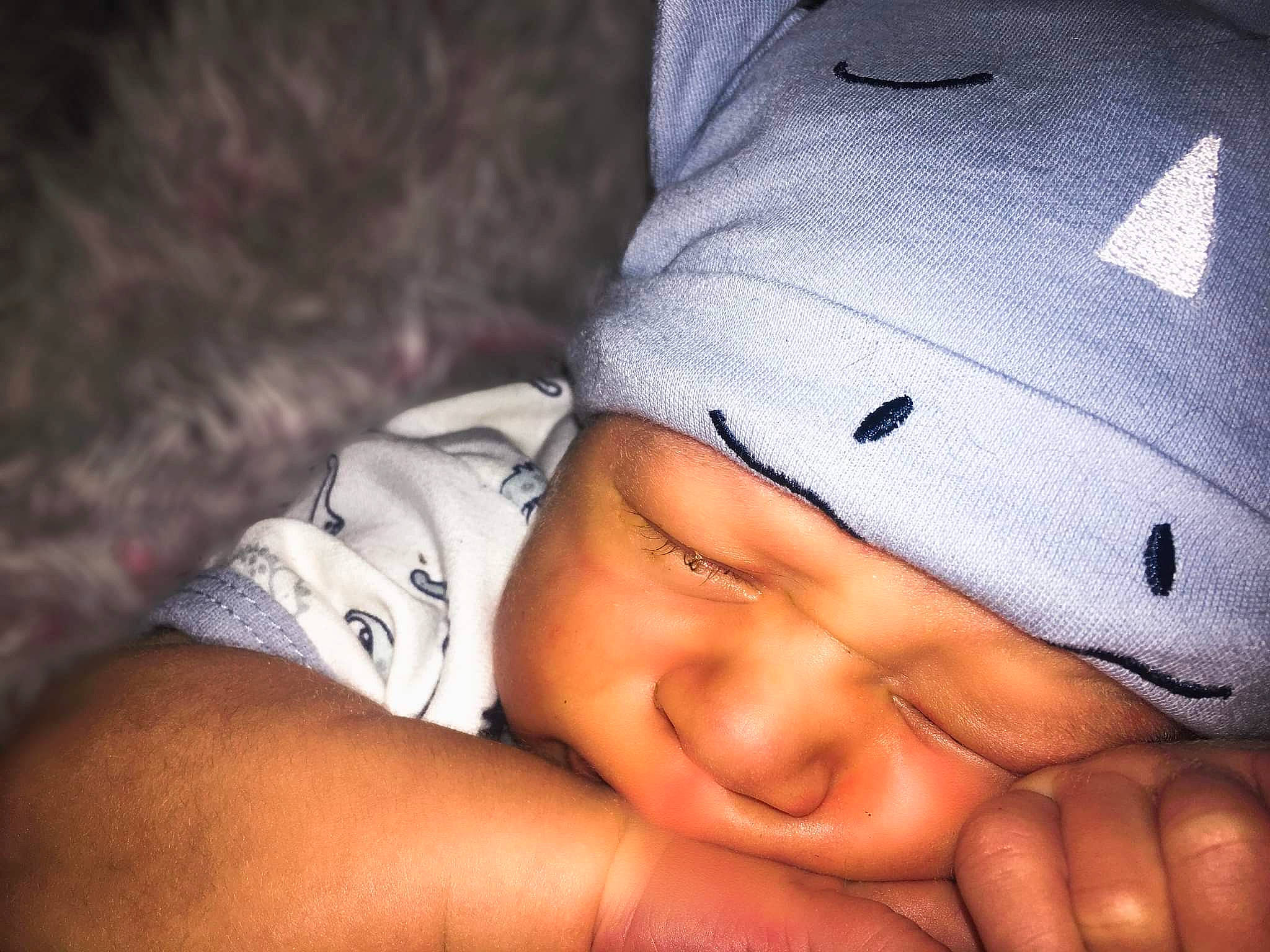 Trevor is registered to the contest to win money with this photo: baby, cap, cheek, comfort, eye, eyebrow, face, finger, flash_photography, gesture, hand, happy, headwear, lip, mouth, nail, nose, person, skin, smile