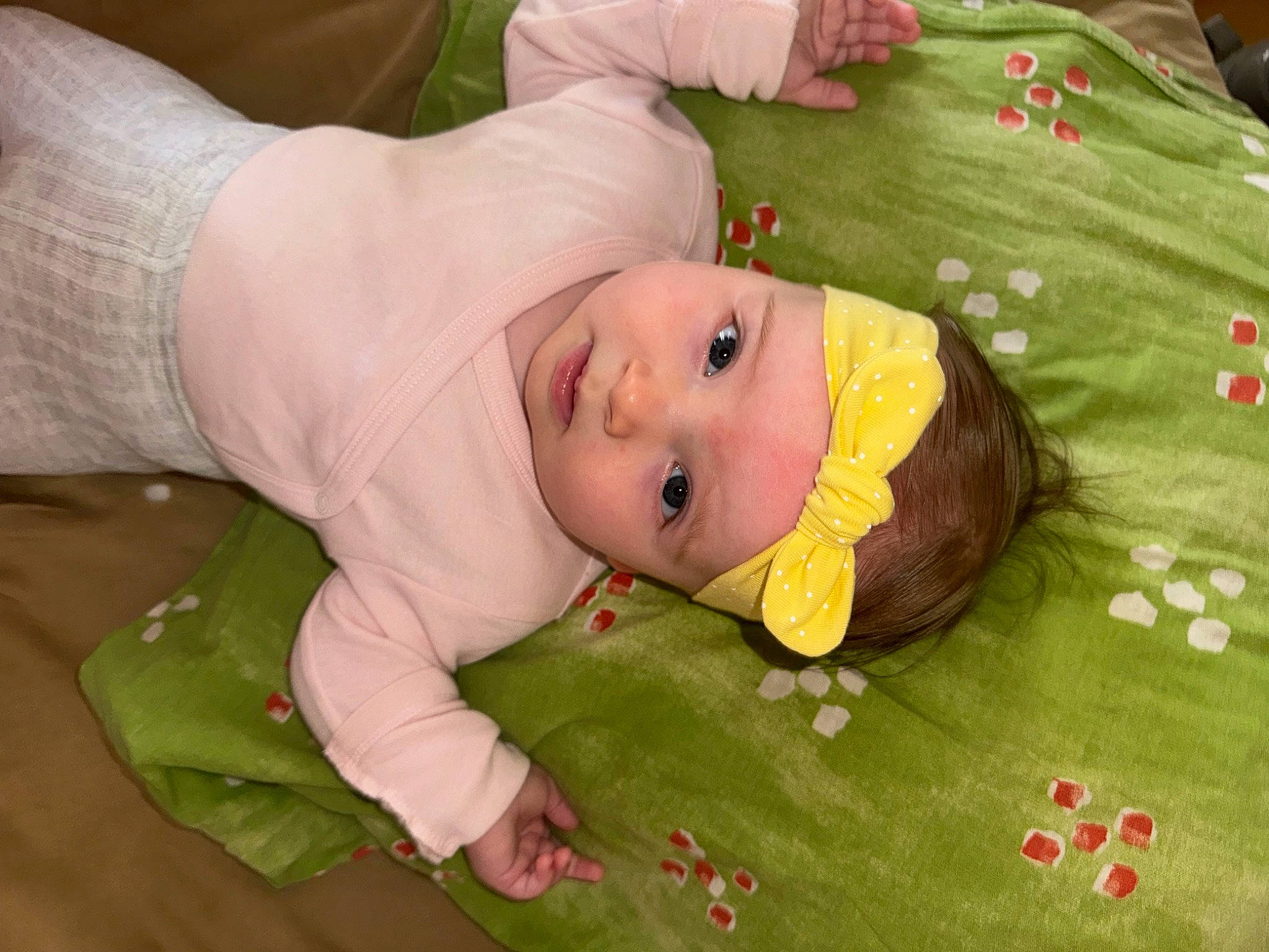 Aëlys a rejoint le concours — aidez-le/la à gagner de superbes lots ! baby, baby_products, baby_toddler_clothing, cheek, child, flooring, grass, green, happy, hat, headwear, linens, person, room, sitting, smile, toddler, tree, wood