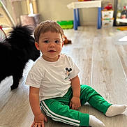 Eliott participe au concours pour gagner de l'argent avec cette photo : black_cat, cat, child, clothing, cute, floor, furniture, green_pants, indoor, mickey_mouse, person, pet, sitting, smile, socks, toddler, toy, white_tshirt, window, wooden_floor